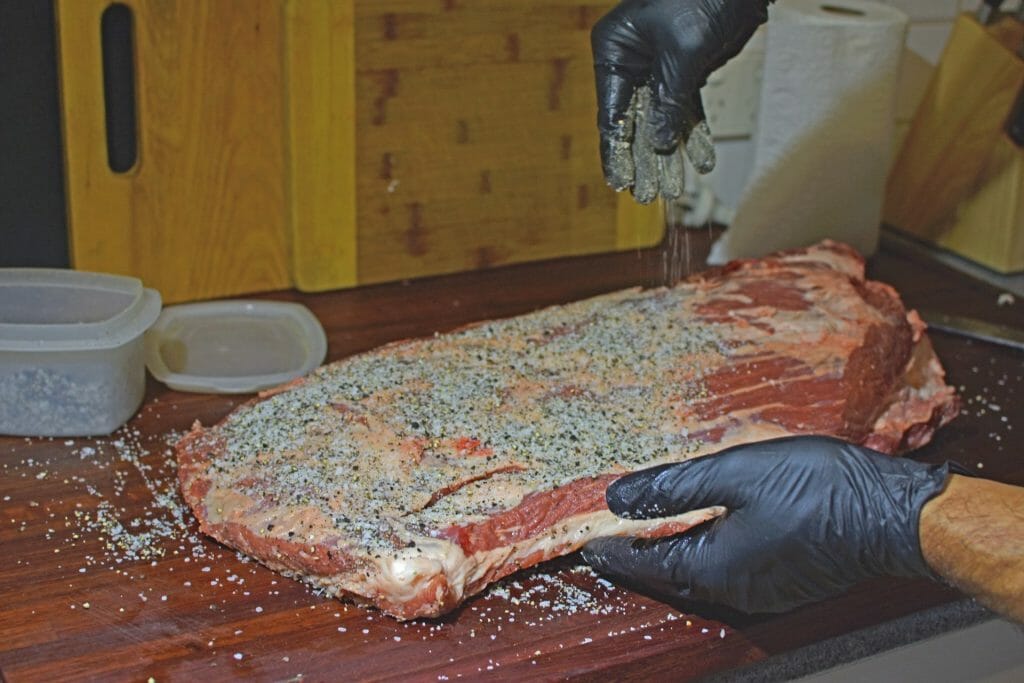rubbing the season on my brisket after applying binder of mustard
