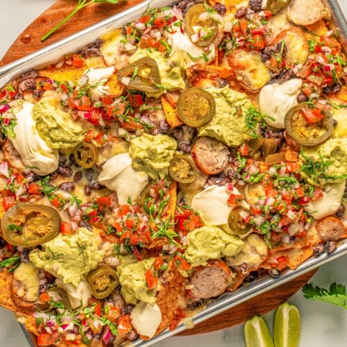 bratchos on a tray with cheese and toppings