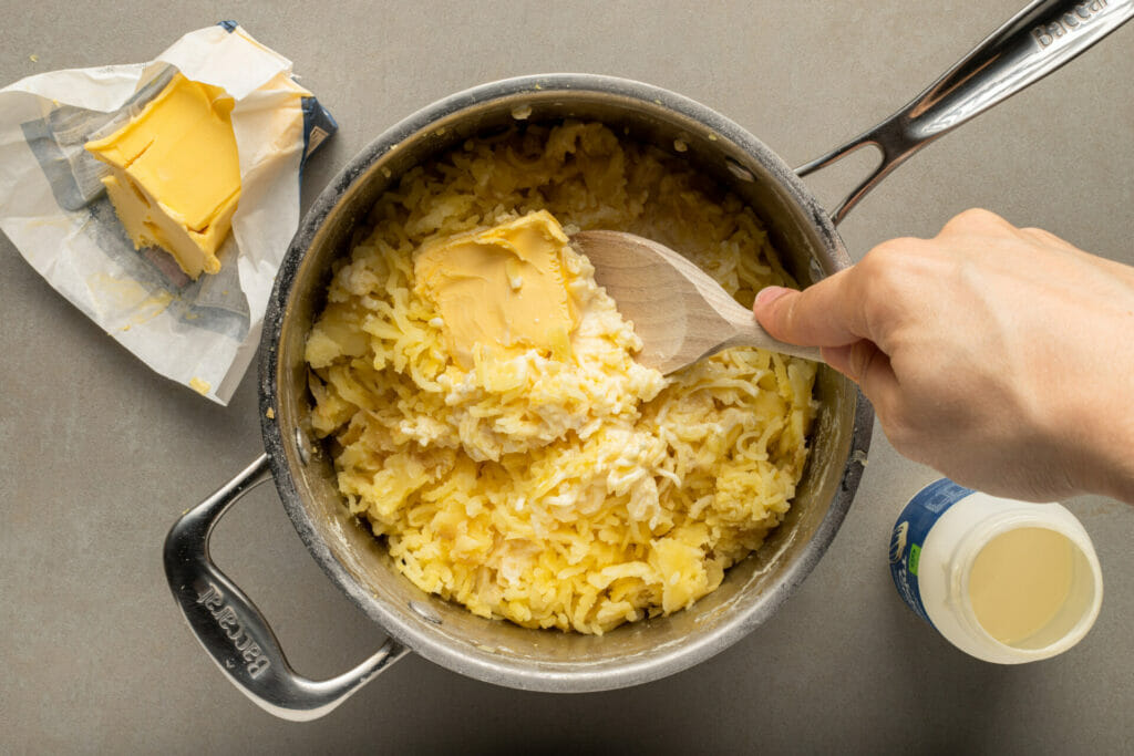 smoked-mashed-potatoes-puuting-butter-in